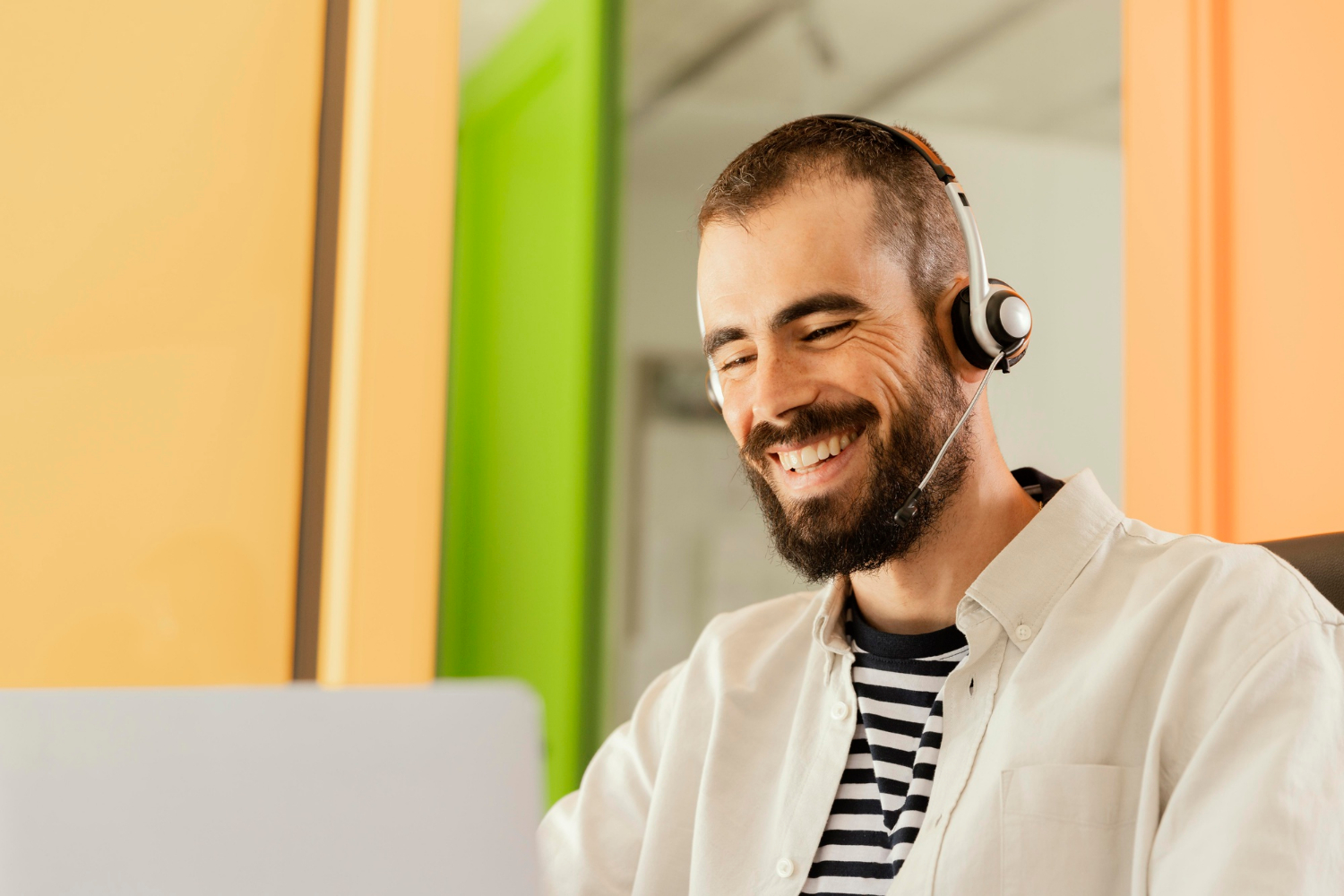 Operador de BPO sorrindo com headset em frente ao notebook - case de IA Analytics e segurança eletrônica da Atento com Tripla