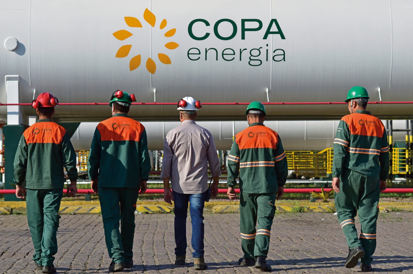 Equipe técnica da Copa Energia em frente a tanque de armazenamento - case de SOC/MDR com CyberWatch da Tripla